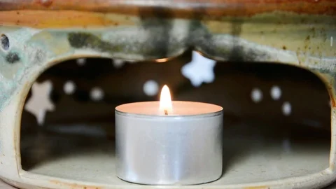 Tea light burning in a ceramic teapot warmer Stock Footage 71315435