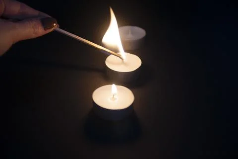 Tea light candle being lit by a woman with nice nails and a long match Stock Photos