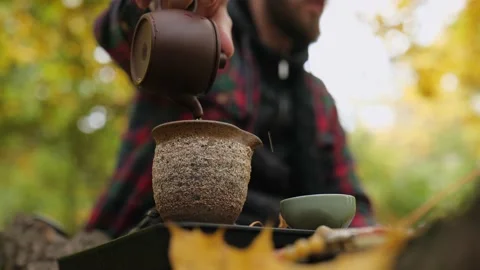 A tea master with a beard pours brewed pu-erh tea from a clay teapot Stock Footage 220415517