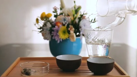 The tea master pours boiling water into a glass cup from a glass teapot Stock Footage 220341787