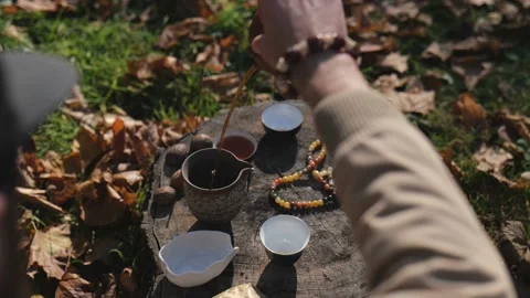 Tea master pours brewed tea into a clay pot from a clay teapot Stock Footage 229859191