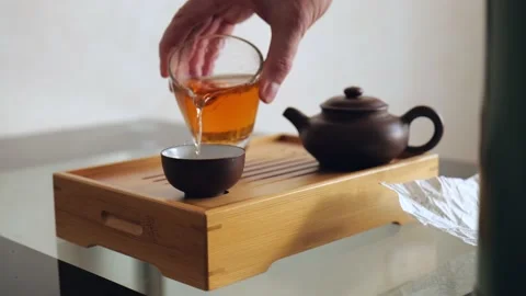 A tea master pours magical chinese tea into bowls in an chinese ceremony Stock Footage 218447450
