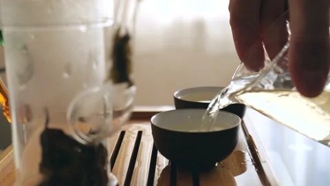 Tea master pours magical chinese tea into bowls in an authentic tea ceremony Видео 220342089