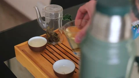A tea master pours white chinese tea into bowls in an chinese ceremony Stock Footage 220342162