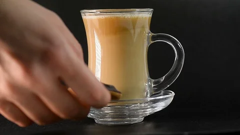Tea with milk, or coffee in a transparent cup. They put cookies on a saucer. Tea Stock Footage 127594627