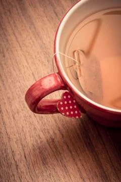 Tea mug on rustic wooden table with heart shaped label Stock Photos