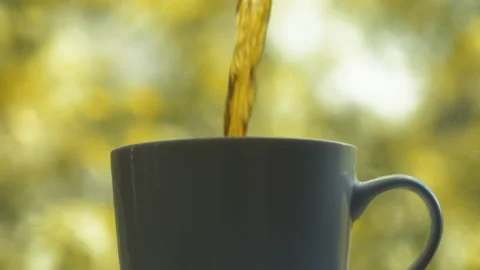 Tea or other liquid is poured into a cup close-up slow motion Video stock 155689378