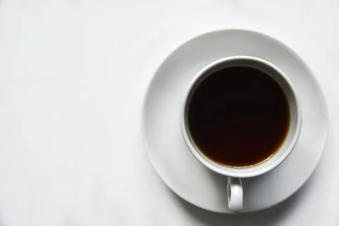 Tea pair with poured tea on a white background. Porcelain cup and saucer with Stock Photos