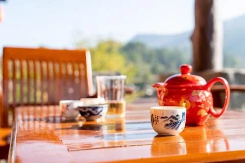 Tea pot and cup on the table with morning sunlight Stock Photos