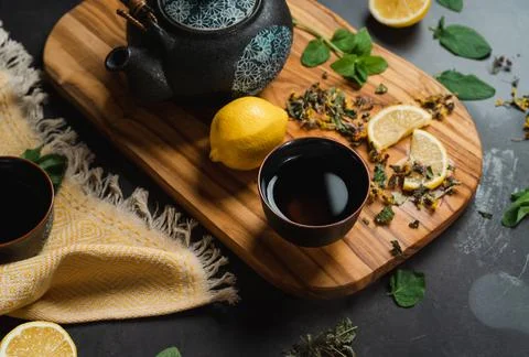 Tea pot with herbs and lemon and honey on wooden board Stock Photos