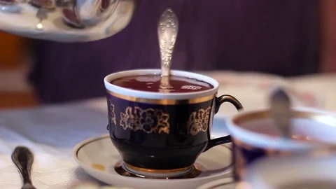 Tea. Pour the tea into the cup. Teapot and Tea Cup on the Table. Stock Footage 73897475