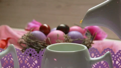 A tea poured in the cup on the background of colored pink Easter egg lies Stock Footage 87662811