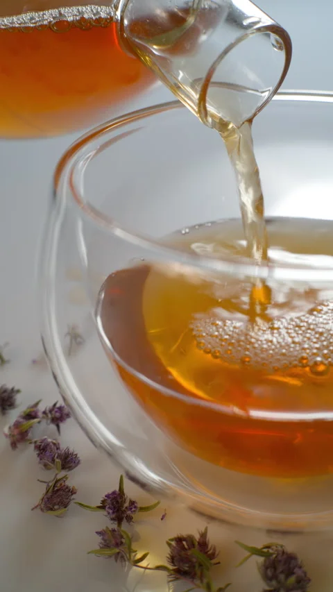 Tea is poured into a glass mug. Vertical. Close-up. Stock Footage 309575335
