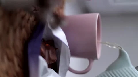 Tea is poured from the kettle into a pink cup Stock Footage 167951134
