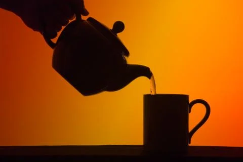 Tea poured from pot into cup Stock Photos