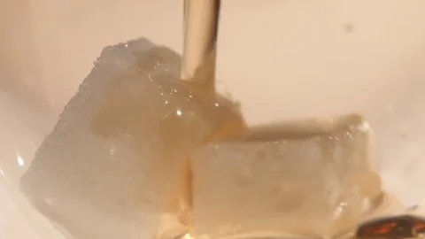 Tea is poured into two pieces of sugar, close up Stock Footage 73766199