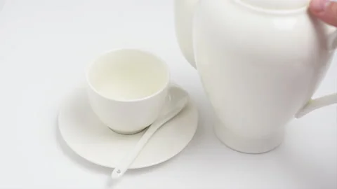 Tea is poured into a white Cup from a white teapot on a white background Stock-Footage 135382076