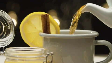 Tea pouring into a mug with lemon and cinnamon Stock Footage 140406041