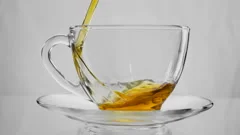 Tea Pouring. Tea Being Poured Into Glass Transparent Tea Cup. Tea