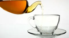 Tea Pouring. Tea Being Poured Into Glass Transparent Tea Cup. Tea