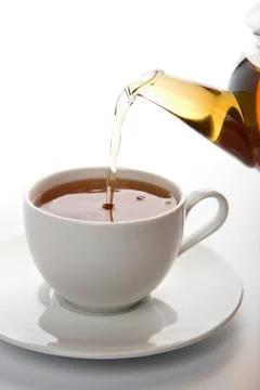 Tea pouring into white cup isolated Stock Photos