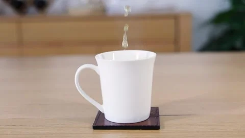 Tea Pouring into White Mug with Splashing Water 库存影片 253393431