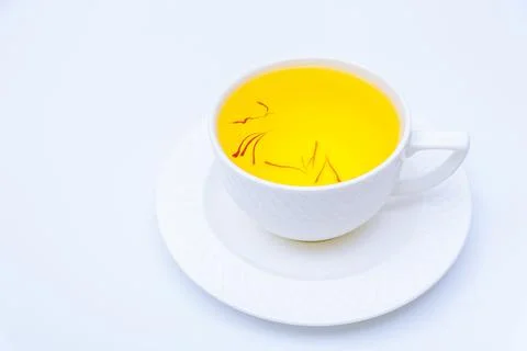 Tea from saffron stamens in a white cup on a white background. Stock Photos