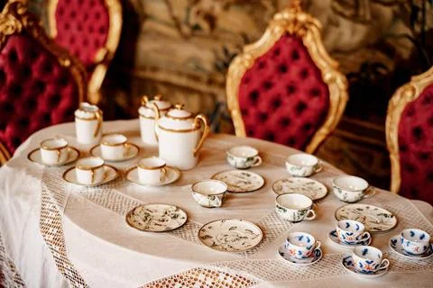 A tea set with a blue pattern and a golden set on a tray on a white mantel... Stock Photos