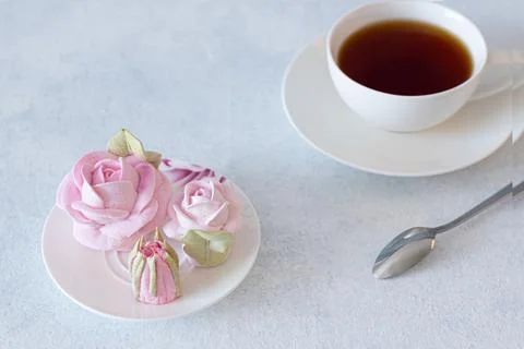 Tea set in a composition with marshmallow flowers. Coffee mug on a saucer. on Stock Photos