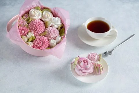 Tea set in a composition with marshmallow flowers. Coffee mug on a saucer. on Stock Photos