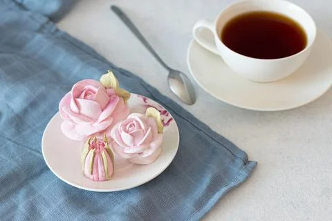 Tea set in a composition with marshmallow flowers. Coffee mug on a saucer. on Foto stock
