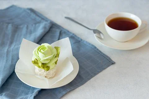 Tea set in a composition with marshmallow flowers. Coffee mug on a saucer. on Stock Photos