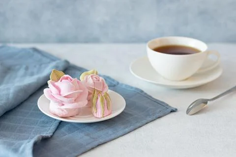 Tea set in a composition with marshmallow flowers. Coffee mug on a saucer. on Foto stock