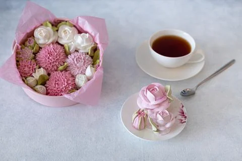 Tea set in a composition with marshmallow flowers. Coffee mug on a saucer. on Stock Photos