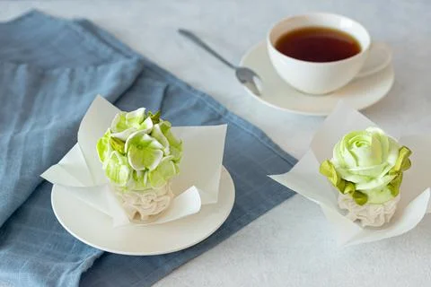 Tea set in a composition with marshmallow flowers. Coffee mug on a saucer. on Stock Photos