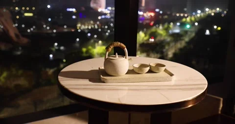 Tea set on a table near window with background Night road lights blurred bo.. Stock Footage 261300090