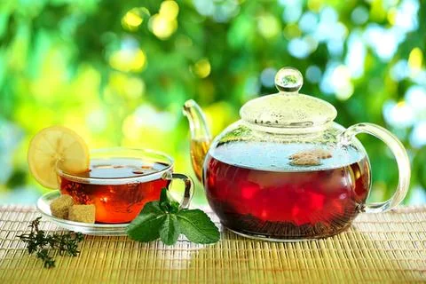 Tea set with teapot and cup on wooden table outdoors Stock Photos