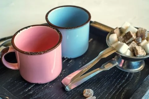 Tea set with two metal cups, sugar tongs and lumps Foto stock
