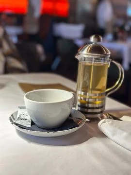 Tea setting featuring a cup and a French press. Soft focus background enhance Stock Photos