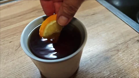 Tea splash with falling citrus wedge Vidéo 307494111
