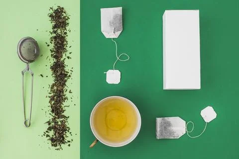 Tea strainer tea bag white boxes green background Stock Photos
