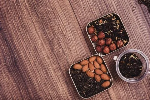 Tea strainer with tea on a wooden surface. Green and black tea Top view wit.. Stock Photos