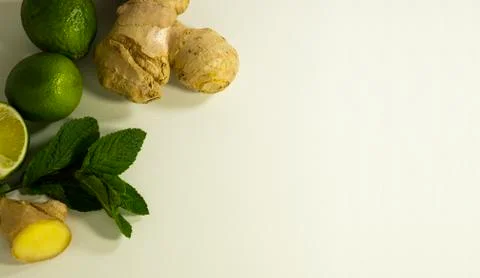 Tea supplement ginger root, peppermint leaves and lime fruit. Copy space. Stock Photos