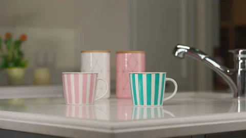 Tea table setting. Two mugs and utensils for tea and sugar stand on a white Vidéo 173552813
