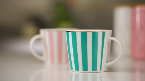 Tea table setting. A white mug with pink stripes and a white mug with tiffany Vídeo Stock 173555811