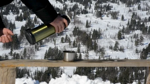 Tea from a thermos on the background of snow-capped mountains, in winter on a wa Stock Footage 105040678