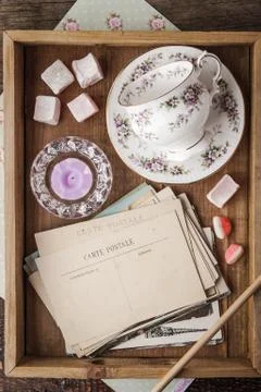 Tea things with sweets and postcards on the wooden tray Stock Photos