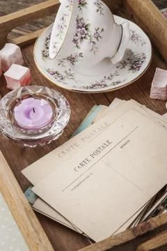 Tea things with sweets and postcards on the wooden tray vertical Stock Photos