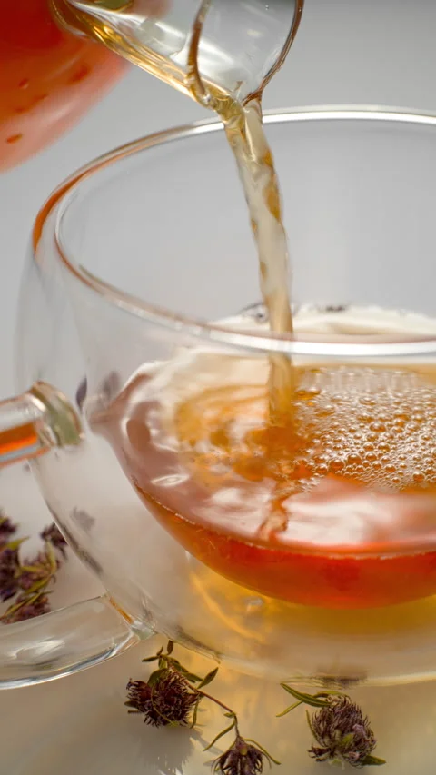 Tea with thyme is poured into a mug. Stock Footage 309576073
