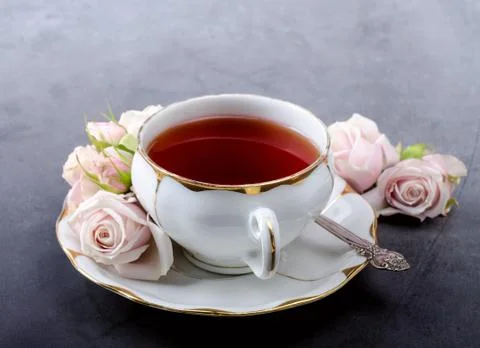 Tea time backdrop with vintage white porcelain tea cup, gentle pink roses on  Stock Photos